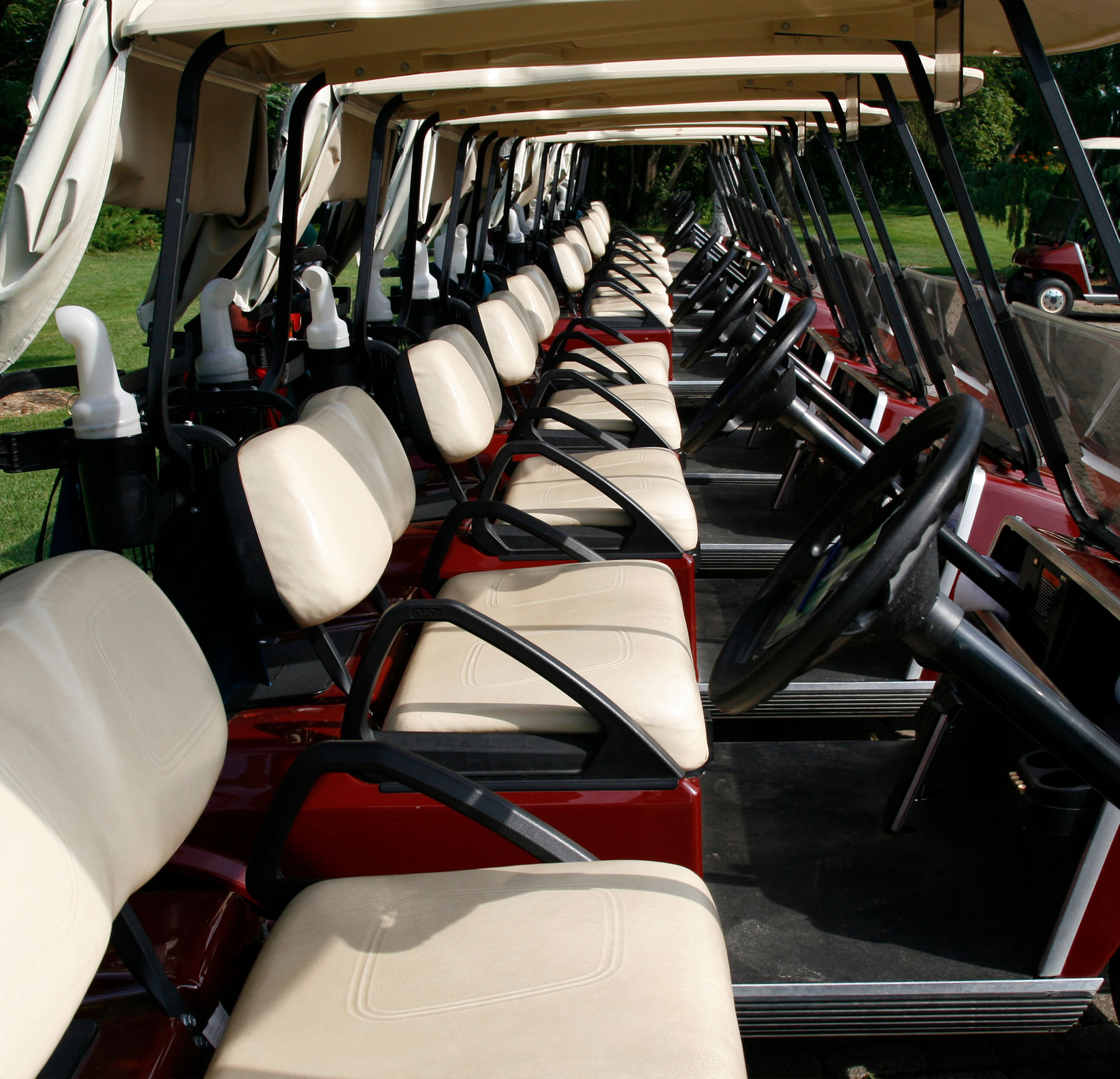Golf carts in a row focused on the seats