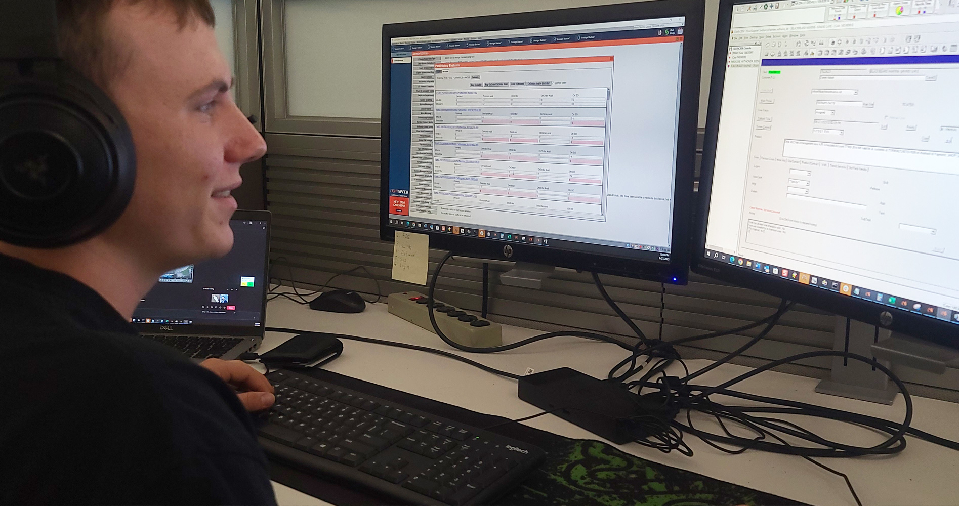 A man smiling at two computer monitors