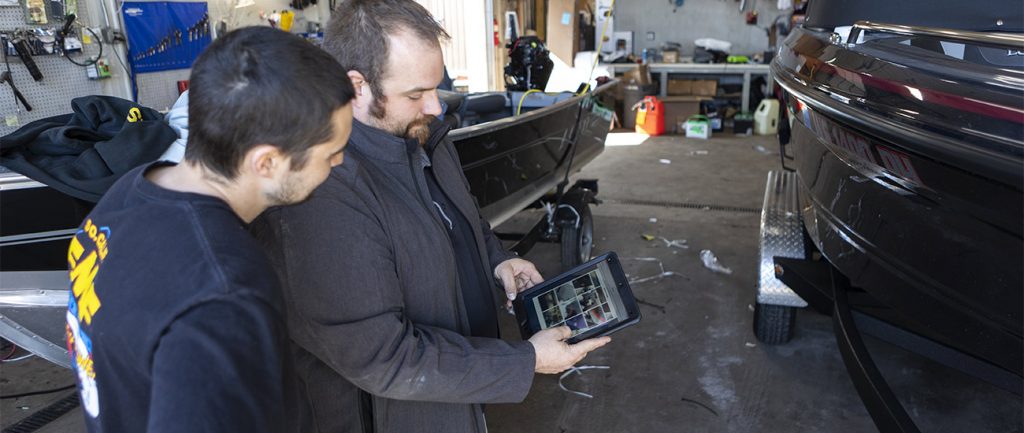 Two men looking at Lightspeed DMS on a tablet