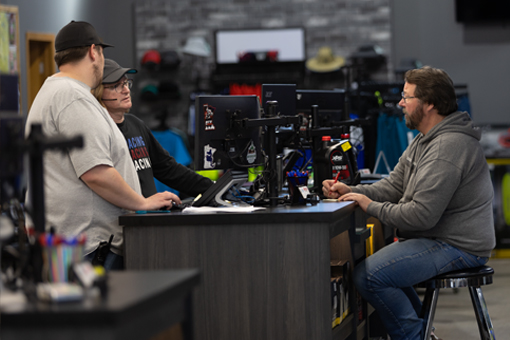Image of two customer service employees and one customer at a counter.