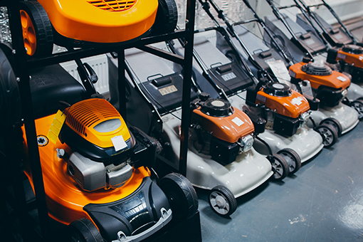 Image of lawn mowers lined up on display.