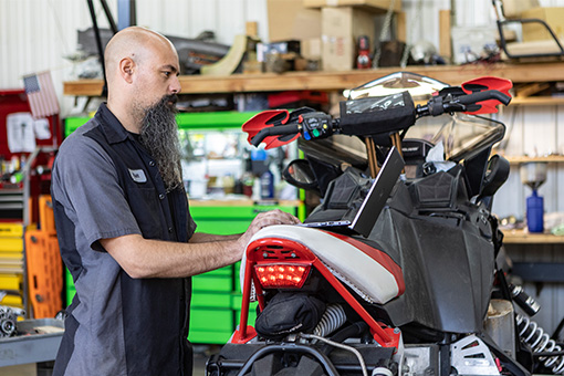 Image of a technician working on a powersports vehicle in a shop.