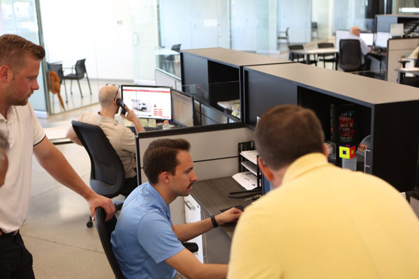 Dealership team collaborating at a computer.